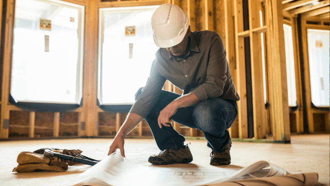 general contractor reading plans in an renovated house