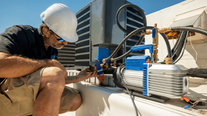 Technician on a rooftop reparing an air system&nbsp;