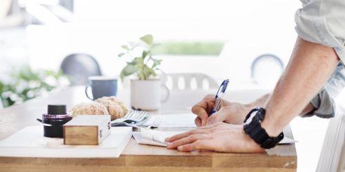 Person signing paper on table